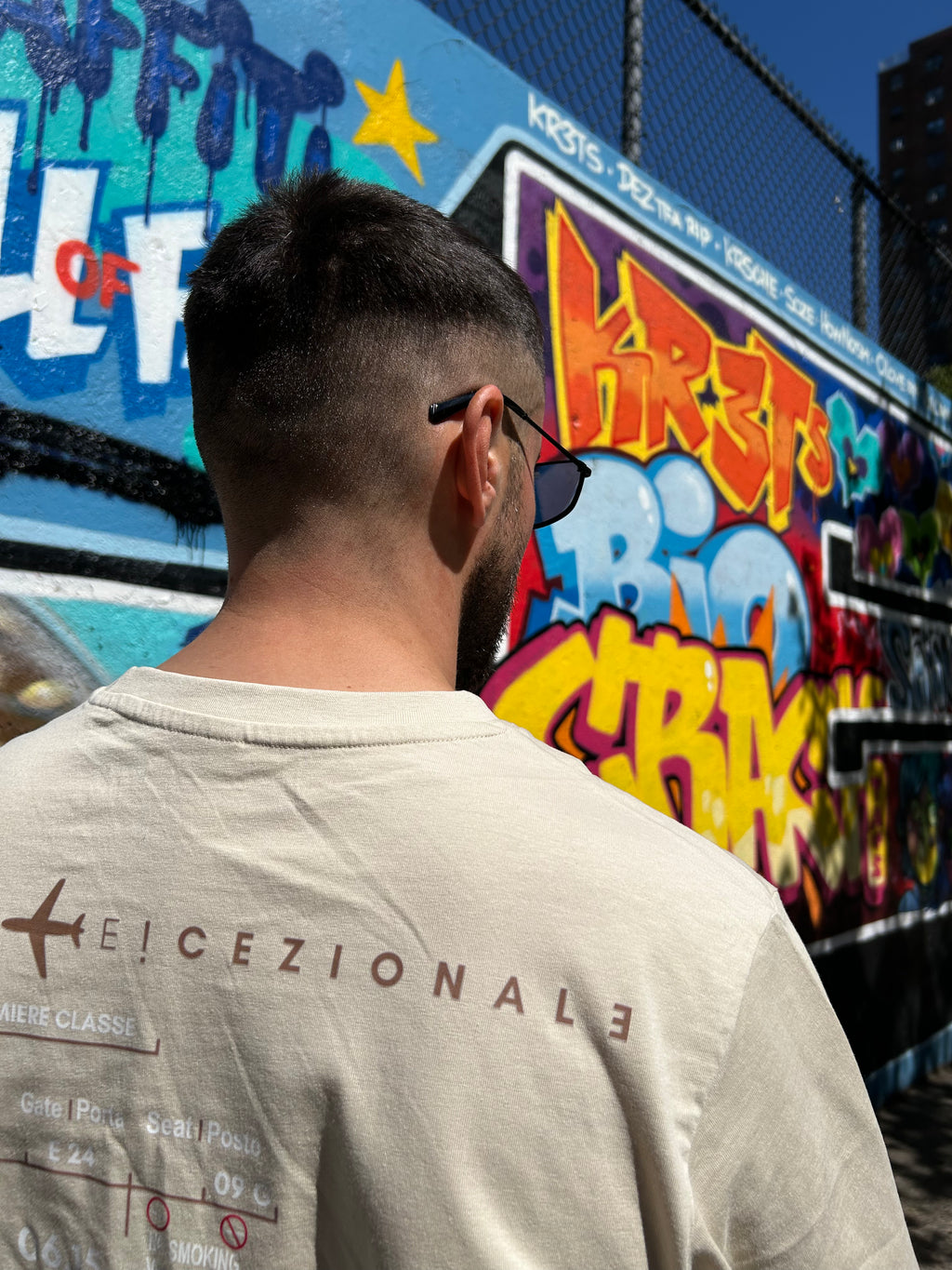 Cliente indossa la TravelTee Beige a New York, street art, foto reale