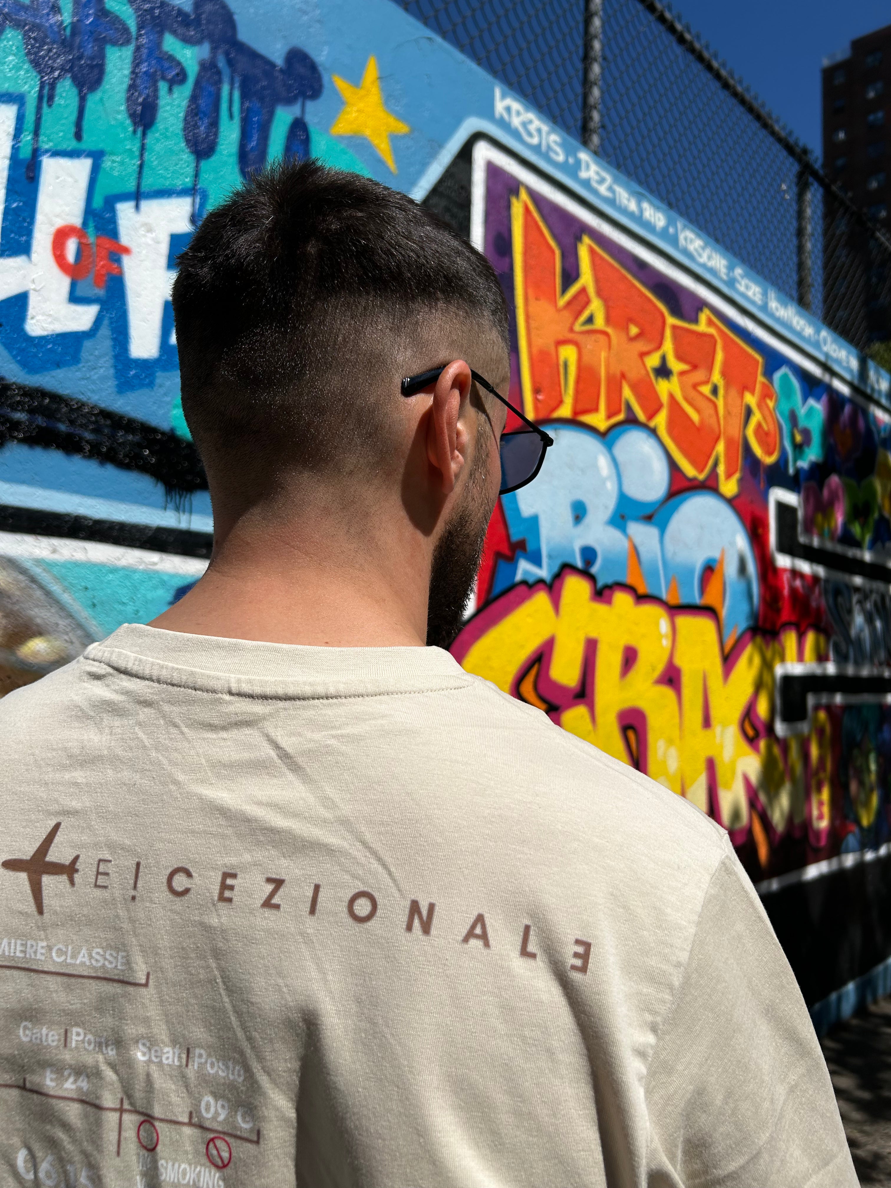 Cliente indossa la TravelTee Beige a New York, street art, foto reale